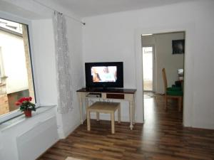 a living room with a television on a table with a chair at Haus Janne in Zell an der Mosel