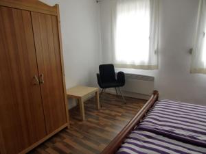 a bedroom with a bed and a desk and a chair at Haus Janne in Zell an der Mosel
