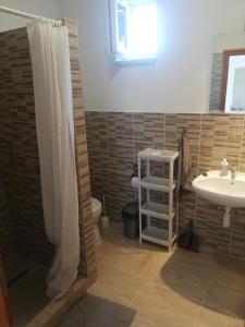 a bathroom with a shower curtain and a sink at Total Relax Apartmanház in Bogács
