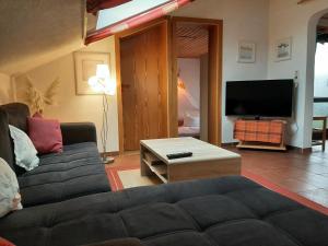 uma sala de estar com um sofá e uma televisão de ecrã plano em Ferienwohnung Evangeline Borsch em Zell an der Mosel