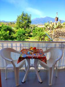 a table and two chairs on a balcony at La casa del sole "tra l'Etna e il mare" in Acireale