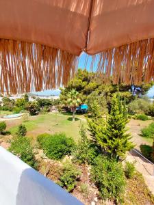 a view of a garden from a patio umbrella at Siesta Mar Apartamentos Ibiza in Santa Eularia des Riu