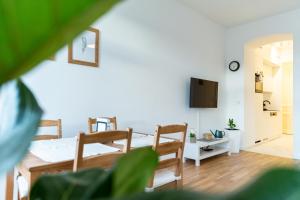 een woonkamer met een tafel en stoelen en een televisie bij Central Apartment in Wenen