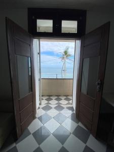 eine offene Tür zu einem Zimmer mit Meerblick in der Unterkunft Apartamento frente mar na Barra, Salvador-BA in Salvador