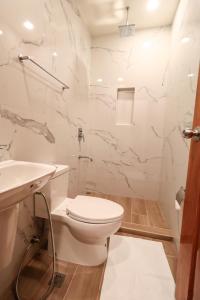 a bathroom with a toilet and a sink at Josefina's Tourist Inn in Busuanga