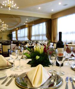 聖菲的住宿－InterTower Hotel，用餐室配有带玻璃杯的桌子和一瓶葡萄酒