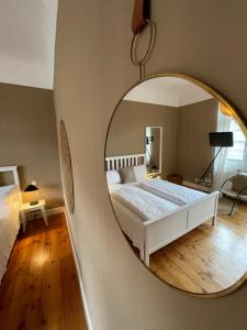 a bedroom with a bed and a round mirror at AUERSTEIN-Hotels auerstein & auerstein-mono in Heidelberg +152 photos
