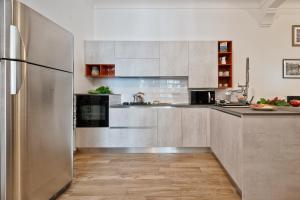a kitchen with stainless steel appliances and a refrigerator at Casa LENA by Apartments To Art in Turin +17 photos