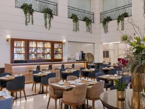 un restaurante con mesas y sillas y un bar en Herbert Samuel Opera Tel Aviv en Tel Aviv