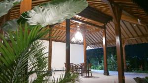 a wooden pavilion with chairs and a table at Sanggar Pantcha Indra in Kemuning