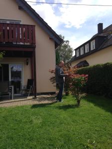 een man in de tuin van een huis bij Ferienwohnung Magma in Lutzerath