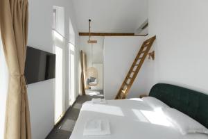 a bedroom with a bed and a tv and a ladder at Buturuga Mică in Nehoiu +39 photos