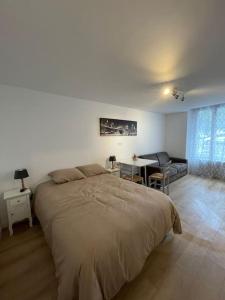um quarto com uma cama grande e uma secretária em LIKEHOME - Studio idéal pour séjour en région parisienne em Villiers-le-Bel