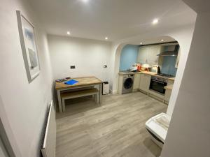 a small kitchen with a wooden table and a tableablish at Sands Reach, dog friendly Tenby house in Tenby