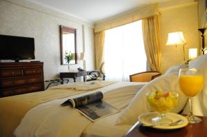 a hotel room with a bed with a tray of food and drinks at InterTower Hotel in Santa Fe