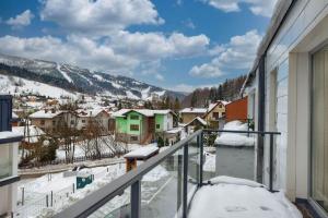 シュチルクにあるSun&Sport Apartamenty CEDROWY i ABIES parking i prywatna sauna w cenieのバルコニーから雪の町の景色を望めます。