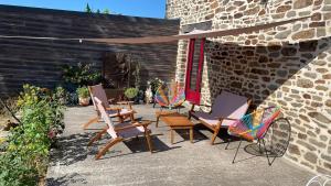 un gruppo di sedie e tavoli su un patio di Chambres d'hôtes Saint-Hélen a Saint-Hélen
