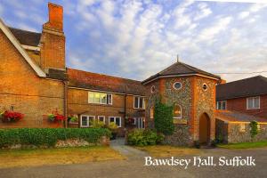 a large brick house with a building with a turret at Bawdsey Hall in Bawdsey