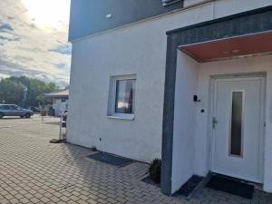 ein weißes Gebäude mit einem Fenster und einer Tür in der Unterkunft iBO-APART 1 Zimmer Apartment in Herzogenaurach in Herzogenaurach