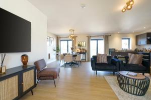 a living room with a couch and a table with chairs at Alba - 2 Bedroom Luxury Apartment by Mint Stays in Bristol