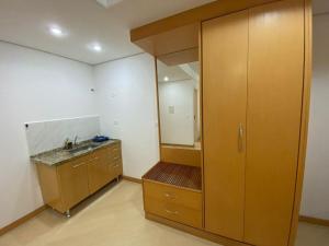 a bathroom with a sink and a large wooden cabinet at Flat Bienal Ibirapuera UH507 in Sao Paulo