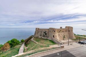 an old castle on a hill next to the ocean at Le Dimore in Ortona
