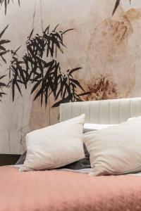een bed met witte kussens in een slaapkamer met een muur bij Le Dimore in Ortona