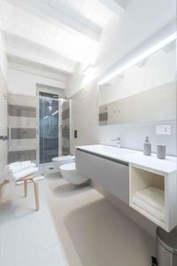 Baño blanco con 2 lavabos y aseo en Le Dimore, en Ortona