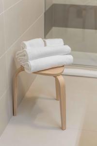 einen Haufen Handtücher auf einem Stuhl im Bad in der Unterkunft Le Dimore in Ortona