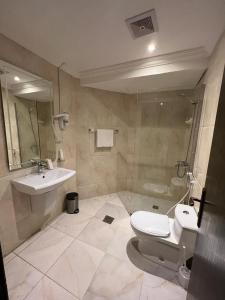 y baño con aseo y lavamanos. en Al Muhaidb Al Taif Hotel en Al Hada