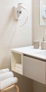 a white bathroom with a sink and towels at Le Dimore in Ortona