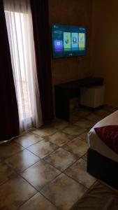 a room with a television and a tiled floor at hôtel MISTRAL in Oran