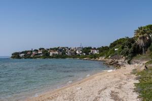 a beach with a town in the background at Yasos By The Sea in Çeşme