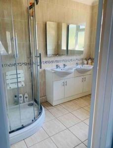 a bathroom with two sinks and a shower at La Mer in Ferring