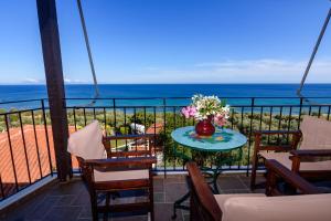 - un balcon avec une table et un vase de fleurs dans l'établissement Eros Pittoresque Retreats - Perfect location, Panoramic Seaview, à Koroni