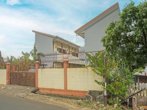 ein Haus mit einem Zaun davor in der Unterkunft SPOT ON 91786 Kilana Homestay in Makassar