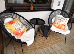 two chairs with pillows on them on a porch at Modernes Apartment mit Traumhaftem Blick ins Grüne in Bräunlingen