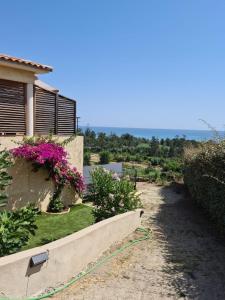 a garden with a hose attached to a house at Casa Peppina - Chez Tonio et Sylvie in Sari Solenzara