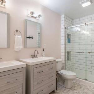 a bathroom with a sink and a toilet and a shower at The Wendover - Entire Home near Lake Michigan! in Norton Shores