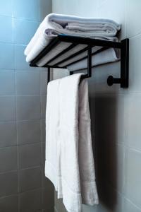 a towel rack with white towels on it in a bathroom at Casa Rural San Andrés de Teixido in Cedeira