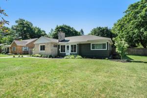 une maison avec une pelouse verte devant elle dans l'établissement The Wendover - Entire Home near Lake Michigan!, à Norton Shores