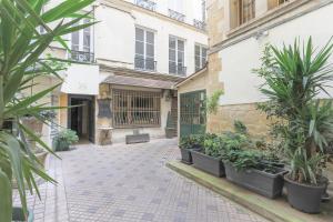 a courtyard with potted plants and a building at Louvre Charmant Studio in Paris