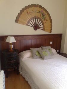 een slaapkamer met een bed en een ventilator aan de muur bij Candelario in Candelario