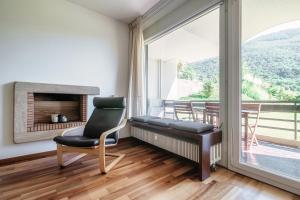 sala de estar con silla y chimenea en Cadro Garden by Quokka 360 - flat with garden view, en Lugano