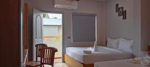 Habitación de hotel con 2 camas y ventana en MOSHIS NEST, en Madurai