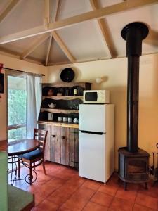 a kitchen with a white refrigerator and a stove at Kalimna Woods Cottages in Lakes Entrance