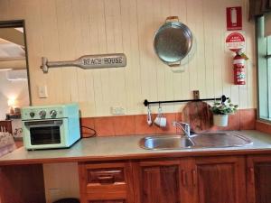 uma cozinha com um lavatório e um micro-ondas em Kalimna Woods Cottages em Lakes Entrance