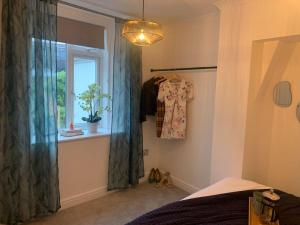 a bedroom with a bed and a window with a shirt at Alto - Lovely 2 Bedroom Serviced Apartment Bristol by Mint Stays in Bristol