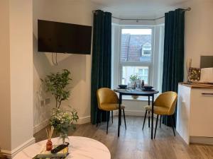 - un salon avec une table et une fenêtre dans l'établissement Alto - Lovely 2 Bedroom Serviced Apartment Bristol by Mint Stays, à Bristol