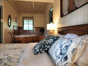 a bedroom with a bed and a bathroom with a sink at Kalimna Woods Cottages in Lakes Entrance